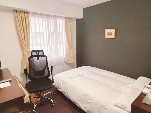 a bedroom with a bed and a desk and a chair at Hotel Shin Osaka / Vacation STAY 81522 in Osaka
