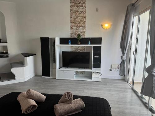 a living room with a tv and a couch at Paraiso Sur & Panoramic Views Apartment, Tenerife in Adeje