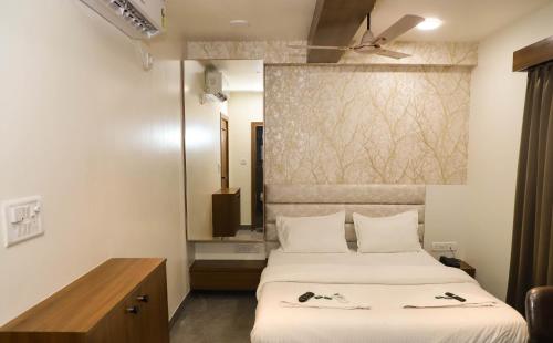 a hotel room with a bed and a mirror at Hotel PNP Royal in Amarnāth
