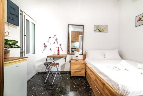 une chambre avec un lit, un bureau et un miroir dans l'établissement Super Cozy Apt near City & Beach, à Thérissos