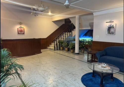 a lobby with a blue couch and a stair case at Imperial House- A Luxury Homestay in Prayagraj