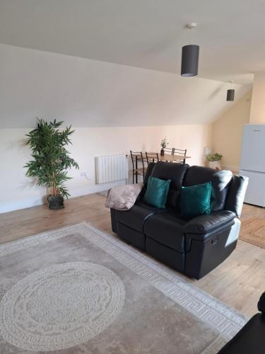 a living room with a black leather couch at Rural retreat in Longframlington