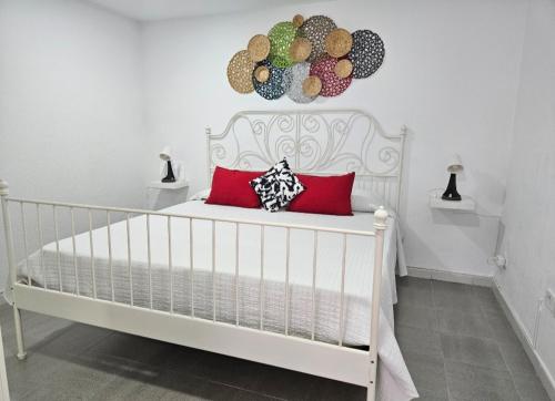 a white bed with red pillows in a room at El Caramelito 3 in San Bartolomé