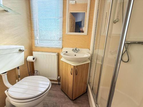 une petite salle de bain avec toilettes et lavabo dans l'établissement Beautiful Caravan At Manor Park Holiday Park In Hunstanton Ref 23060W, à Hunstanton