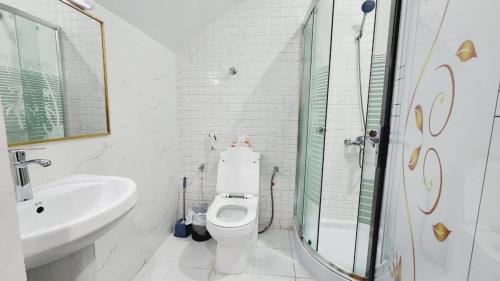 a white bathroom with a toilet and a sink at Blessings property in Abu Dhabi