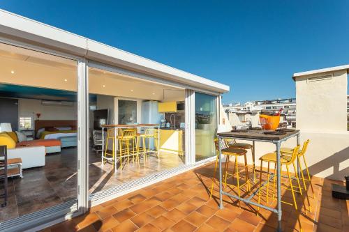 un balcon avec une table et des chaises et une cuisine dans l'établissement Village Naturiste R4N - Villa Bonheur Front Beach, au Cap d'Agde