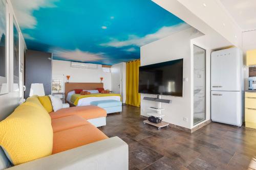 un salon avec un canapé et un lit dans l'établissement Village Naturiste R4N - Villa Bonheur Front Beach, au Cap d'Agde