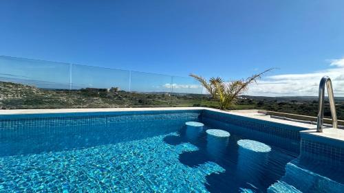a blue swimming pool with a view of the desert at Penthouse in Mellieha with Private Pool & Large Terraces in Mellieħa