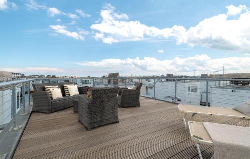 een balkon met rieten stoelen en tafels op een dak bij Sutsche in Olpenitz