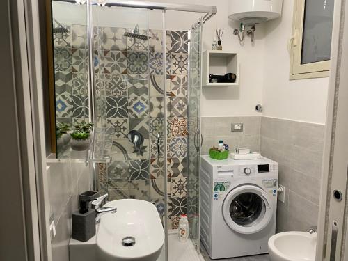a bathroom with a washing machine and a washer at SEA & CITY Apartments in Trapani
