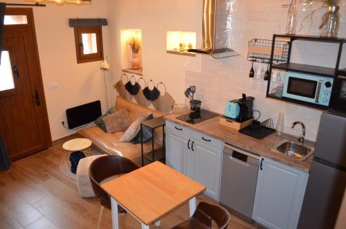 a kitchen and living room with a couch and a table at Casa Rural El Balcón del Castillo in Torija