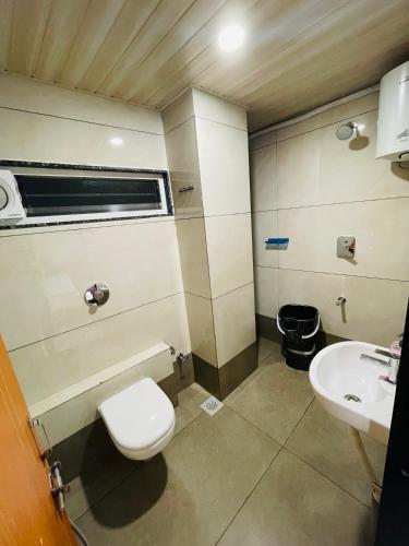 a bathroom with a toilet and a sink at Hotel Coastal Empire in Belgaum
