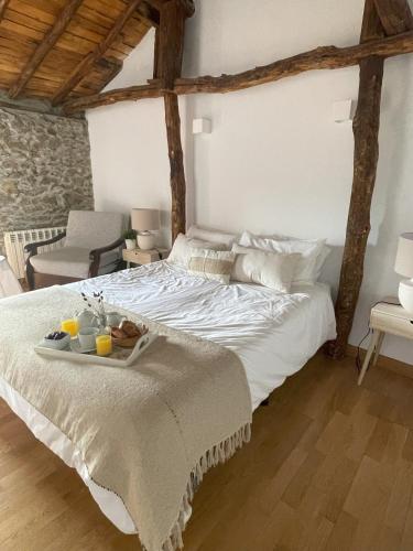 a white bed with a tray of food on it at El Encanto de Bustares in Bustares