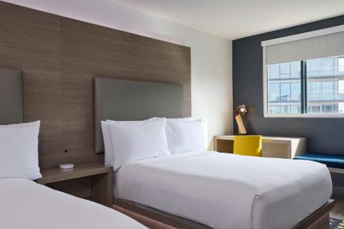 a hotel room with two beds and a window at Aloft Scottsdale in Scottsdale