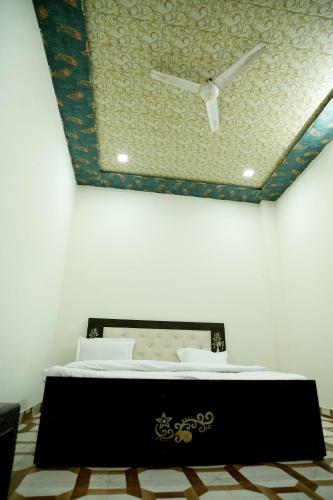 a bedroom with a bed with a ceiling at Shri Gauraj Dham in Chhatikara
