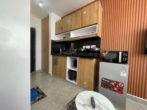 a kitchen with a refrigerator and a microwave at Bliss Apartment Tsavo Fedha near JKIA in Nairobi