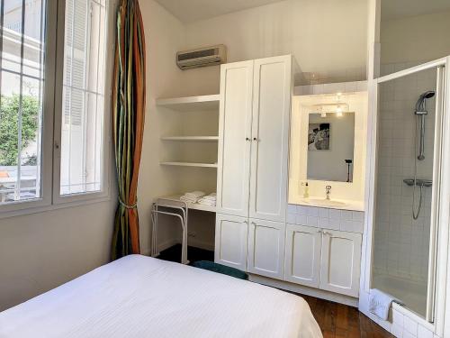 une chambre avec un lit, un lavabo et un miroir dans l'établissement Pura Vida, à Cannes