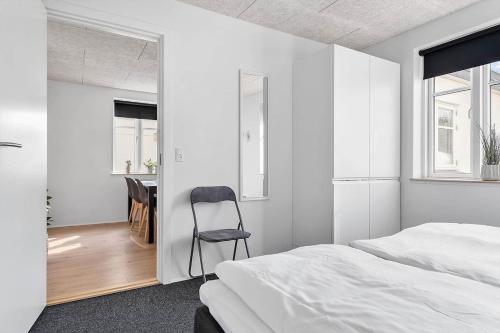 a bedroom with a bed and a chair in it at Newly renovated house in the center in Thyborøn