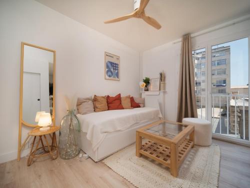 un salon avec un canapé blanc et une table en verre dans l'établissement Spondeo Studio - Plein coeur du Vieux Port, à Marseille