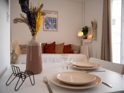 une table à manger avec deux assiettes et un vase dans l'établissement Spondeo Studio - Plein coeur du Vieux Port, à Marseille