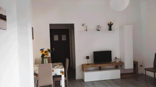 Una pequeña sala de estar con un televisor y una mesa. en La Casina di Orsolina, en Livorno