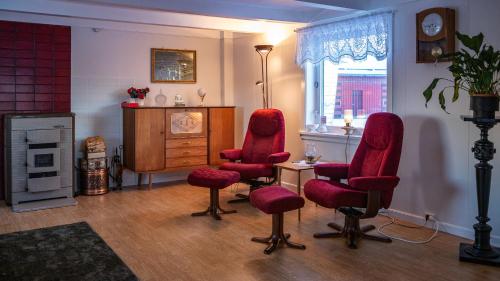 a living room with two red chairs and a table at Charming house with exceptional view in Vestvågøya