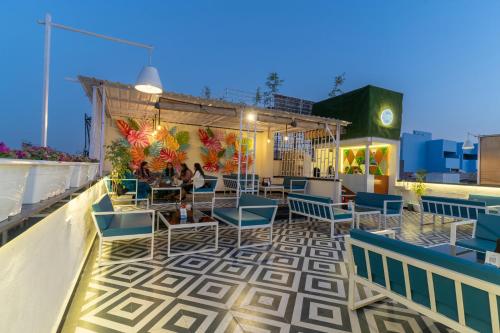 a rooftop patio with chairs and tables on a roof at Storica Stays in Jodhpur