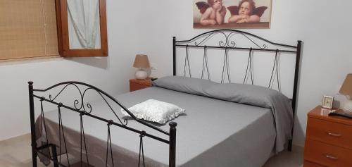 a bedroom with a black bed with a pillow on it at Villa Allori, via degli allori in San Pietro in Bevagna in San Pietro in Bevagna