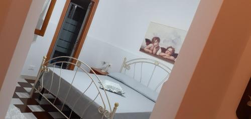 a room with a staircase with a bed and a picture on the wall at Villa Allori, via degli allori in San Pietro in Bevagna in San Pietro in Bevagna