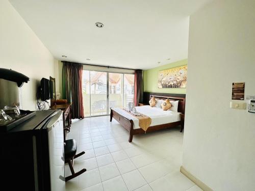 a hotel room with a bed and a large window at Sea Boss Homestay in Kata Beach