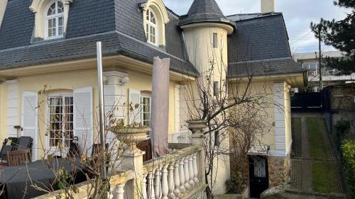 una casa blanca con techo de gambrel en Appartement en souplex, en Rueil-Malmaison
