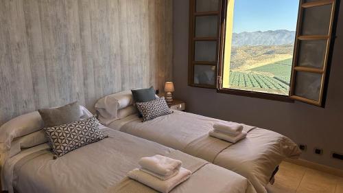two beds in a room with a large window at Desert Springs award-winning Golf Resort apartment in La Hoya del Camaino