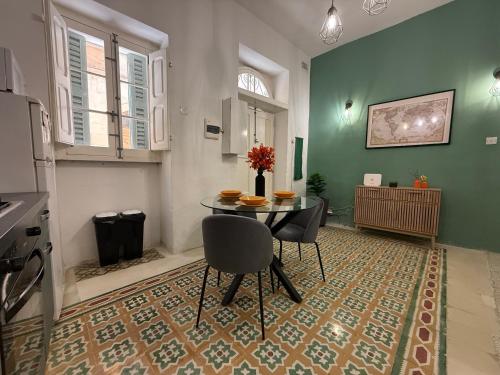 a dining room with a table and chairs on a rug at Entire Apartment in Cospicua with a Cellar! in Cospicua