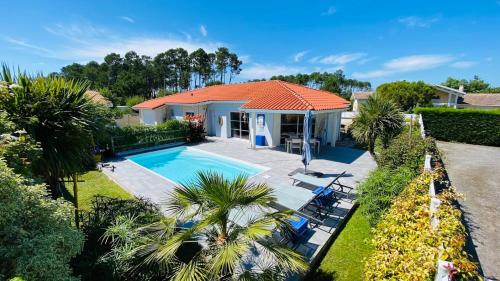 une vue aérienne d'une maison avec piscine dans l'établissement Biscaraibes, à Biscarrosse