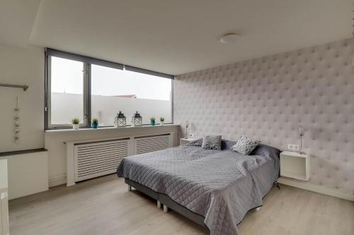 a bedroom with a bed and a large window at Luxury apartment in the center in Medemblik