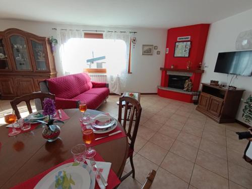 a living room with a table and a red couch at Giò Giò House - Lake Como in Muronico