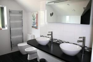 bagno con 2 lavandini e servizi igienici di B&B Dorwyn Manor ad Avebury