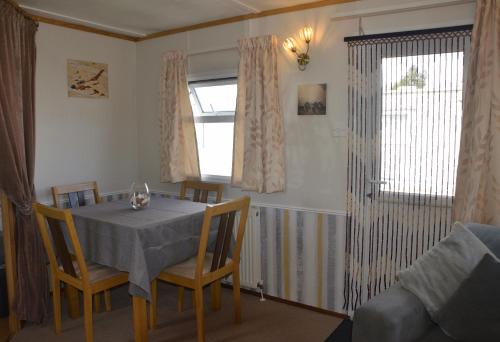 a dining room with a table and chairs and a window at Horseshoe Lake Holidays - 6 berth Static Caravan in Mablethorpe