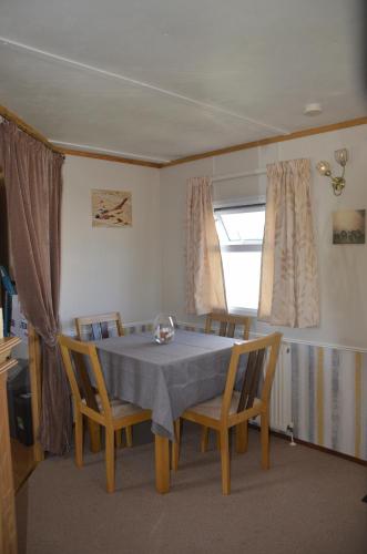 a dining room with a table and chairs and a window at Horseshoe Lake Holidays - 6 berth Static Caravan in Mablethorpe