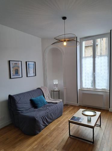 un salon avec un canapé et une table dans l'établissement Art Nouveau & Nancy Thermal - Appartement F2 paisible de qualité, à Nancy