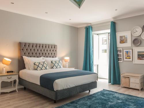 a bedroom with a large bed with blue curtains at Vila Garden Guesthouse in Lisbon