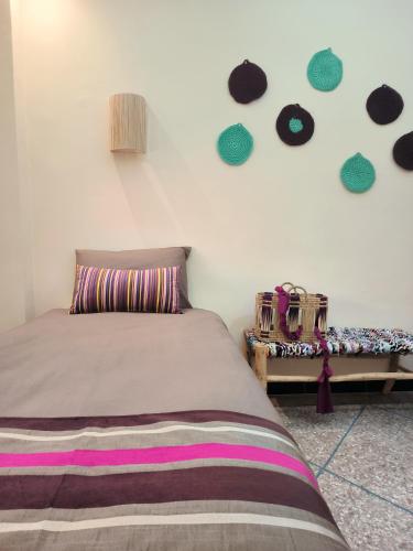 a bedroom with a bed and a wall with stickers at Maktub Maroc Surf & Mind in Agadir