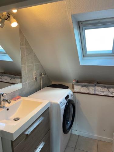 une machine à laver dans une salle de bain avec un lavabo dans l'établissement Appartement Ô Nid Perché Vue mer, à Agon-Coutainville