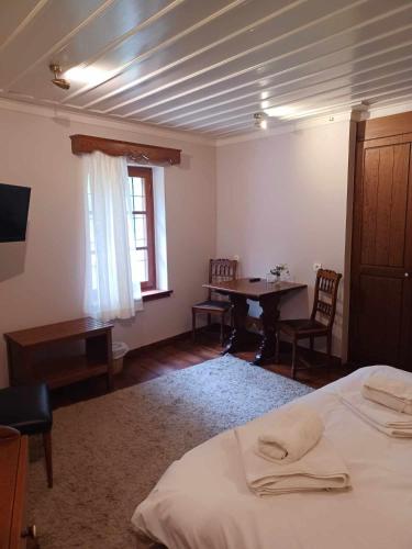 a bedroom with a bed and a table and a window at En Chora Vezitsa in Vitsa