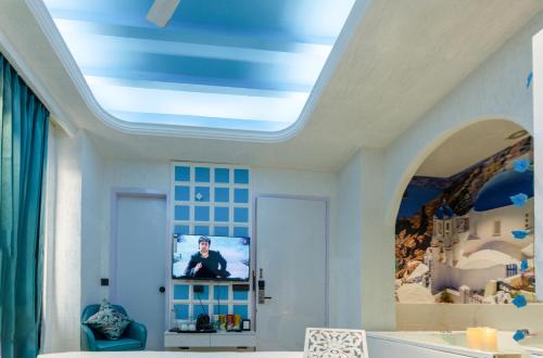 a room with a ceiling with a tv on it at Orsom Stays Sassy Sector 53 in Gurgaon