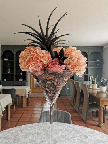 a glass vase with flowers in it on a table at A Flor da Rosa in Vila Nova de Foz Coa