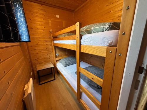 a room with two bunk beds in a cabin at Camping & Chalets La Santoire in Saint-Bonnet-de-Condat