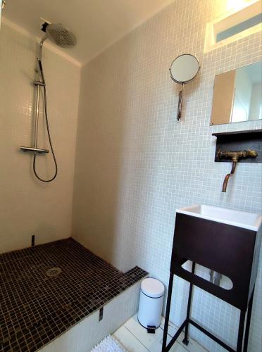 une salle de bain avec une douche, un lavabo et un tabouret dans l'établissement Les Grands Cyprès - chambres d'hôtes, à Conques-sur-Orbiel