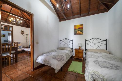 sypialnia z dwoma łóżkami i jadalnią w obiekcie CASA CRUZ EL LLANO w mieście El Pinar