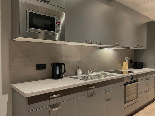 a kitchen with a sink and a microwave at A & B Apartment und -Zimmervermietung in Tornesch
